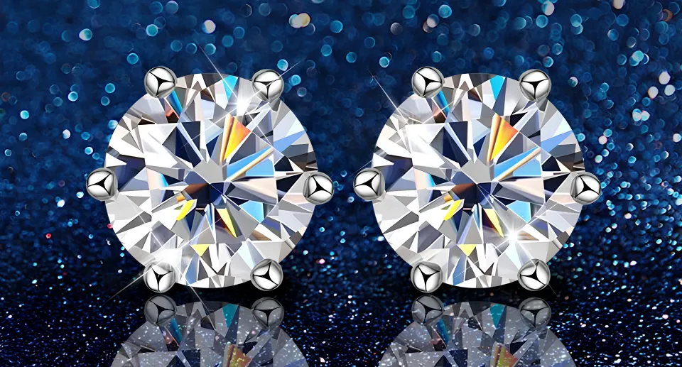 Moissanite engagement ring next to lab-grown and natural diamond rings on a white jewelry tray